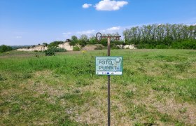 Schöner Platz am Plateau, © Marktgemeinde Ravelsbach Ein Schild mit der Aufschrift 'Foto Punkt' steht auf einer grünen Wiese unter blauem Himmel.