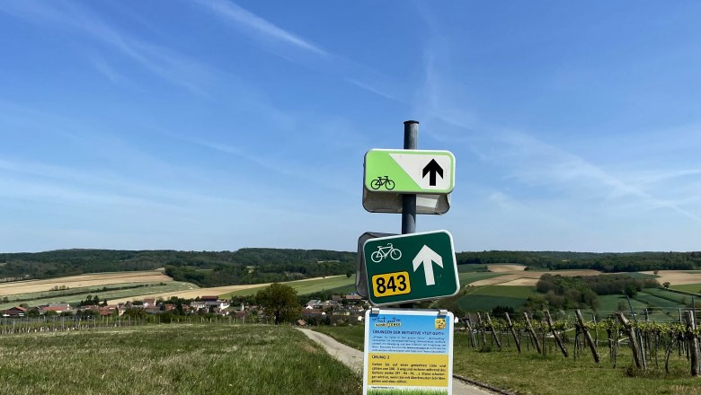 Schöner Ausblick am Radweg bei Oberthern, © Weinstraße Weinviertel Wegweiser am Radweg bei Oberthern mit Feldern im Hintergrund.