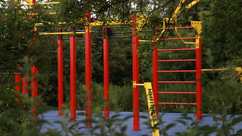 Ziersdorf Calisthenics, © LEADER Weinviertel-Manhartsberg Ein Calisthenics-Park mit roten und gelben Stangen, umgeben von grüner Vegetation.