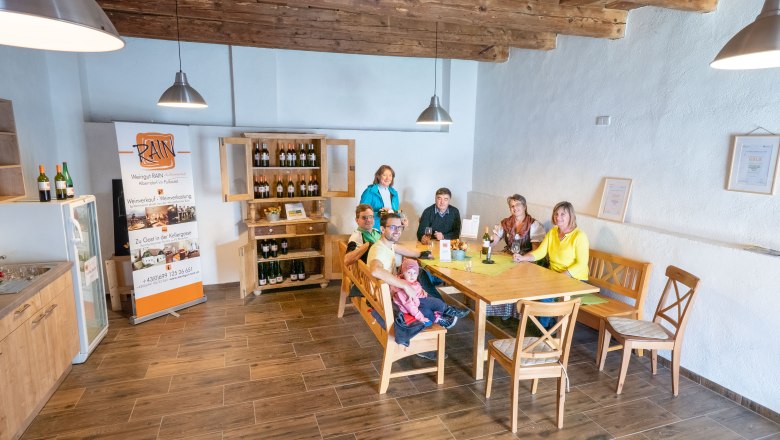 Keller-Wohlfühlplatz Alberndorf, © Initiative Pulkautal / P. Mödl Eine Gruppe von Menschen sitzt an einem Tisch in einem gemütlichen Raum mit Holzboden und -decke.