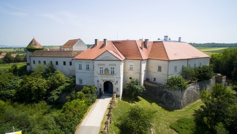 Schloss Mailberg, © Schlosshotel Mailberg / Malteser Ritterorden Luftaufnahme von Schloss Mailberg mit roten Dächern und umgebender Landschaft.
