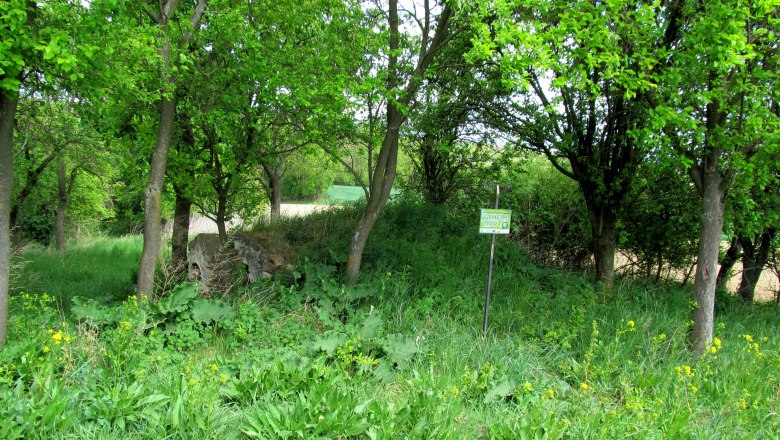 Hiata Hütte Pfaffstetten, © Marktgemeinde Ravelsbach Grüne Wiese mit Bäumen und einem Schild mit der Aufschrift 'Geheimtipp'.