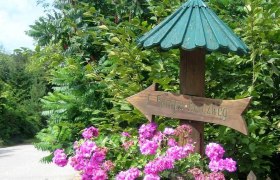 Europakreuzweg auf den Manhartsberg, © Marktgemeinde Hohenwarth-Mühlbach Holzschild mit Aufschrift 'Europakreuzweg' und rosa Blumen.