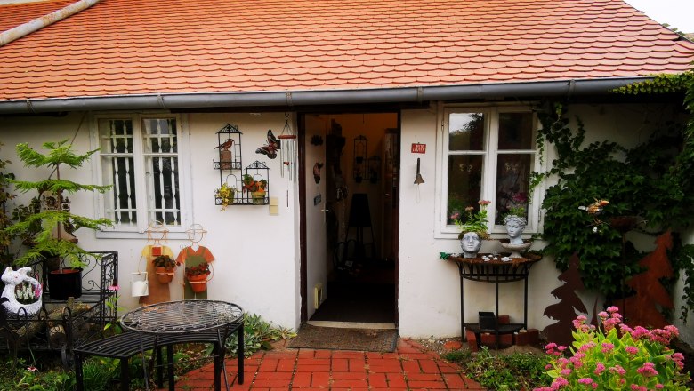 Keramik Slama, © Weinstraße Weinviertel Eingang eines Hauses mit roten Dachziegeln, dekoriert mit Pflanzen und Keramikfiguren.
