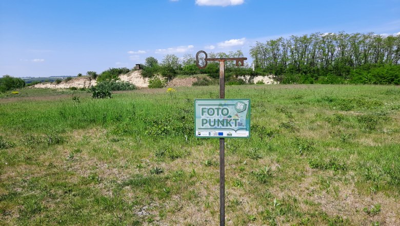 Schöner Platz am Plateau, © Marktgemeinde Ravelsbach Ein Schild mit der Aufschrift 'Foto Punkt' steht auf einer grünen Wiese unter blauem Himmel.