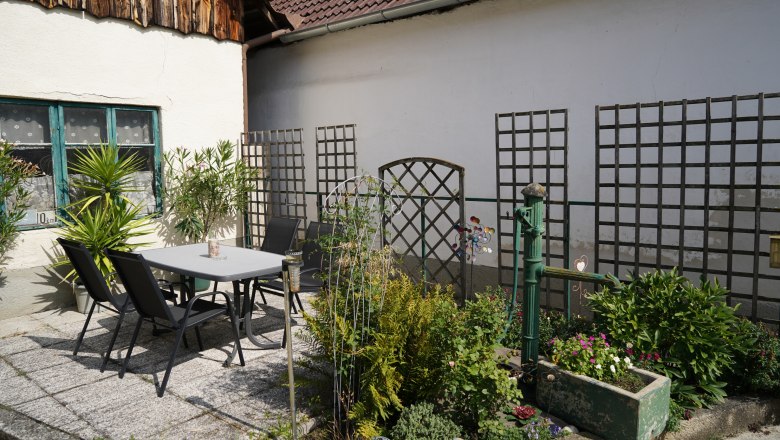 Landhaus Krell, © Weingut Krell Ein gemütlicher Innenhof mit Tisch, Stühlen und Pflanzen.