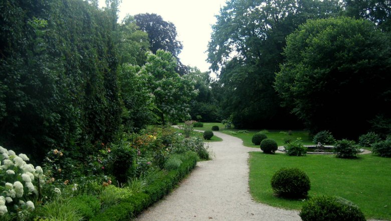 Schlosspark Mühlbach, Dirndlweg, © Marktgemeinde Hohenwarth-Mühlbach Ein gepflegter Gartenweg im Schlosspark Mühlbach, umgeben von Büschen und Bäumen.