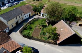 Luftaufnahme eines Bauernhofs mit Garten und umliegenden Geb&auml;uden in Deinzendorf.