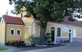 Außenansicht des Retzbacher BauernShops mit gelber Fassade und rotem Dach.
