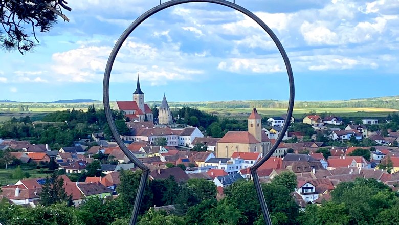 Blick auf Pulkau durch einen Metallrahmen mit Schild 'Weinstra&szlig;e Weinviertel'.