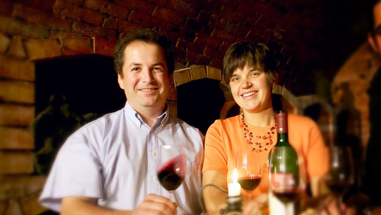 Fam. Krottendorfer, © Lehmann Ein Mann und eine Frau sitzen an einem Tisch mit Wein und Kerze.