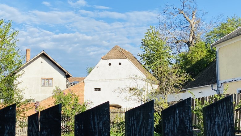 H&auml;user und Garten hinter einem Holzzaun in Deinzendorf, Weinviertel.