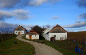 Weinkeller in einer ländlichen Landschaft mit blauem Himmel und Wolken.