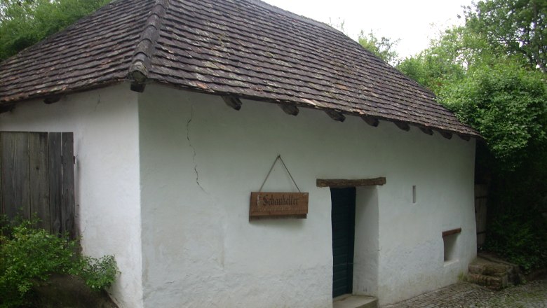 Ein traditionelles Geb&auml;ude mit wei&szlig;er Fassade und Ziegeldach, beschriftet als 'Schaukeller'.