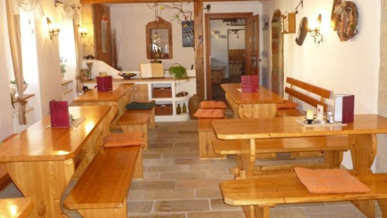 Innenansicht eines traditionellen Heurigenlokals mit Holztischen und Bänken.