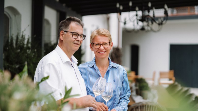 Zwei Personen stehen drau&szlig;en und halten Weingl&auml;ser.