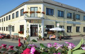 Außenansicht des Retzerlandhofs mit Terrasse und Blumen.