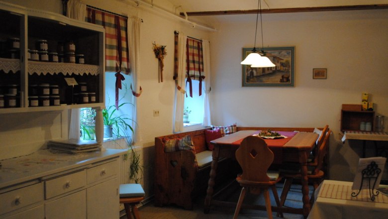 Ferienwohnung, © Fam. Pointner Gemütliche Küche mit Holzmöbeln und karierten Vorhängen.