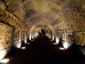 Ein beleuchteter Tunnel mit kunstvoll geschnitzten W&auml;nden und Decken.