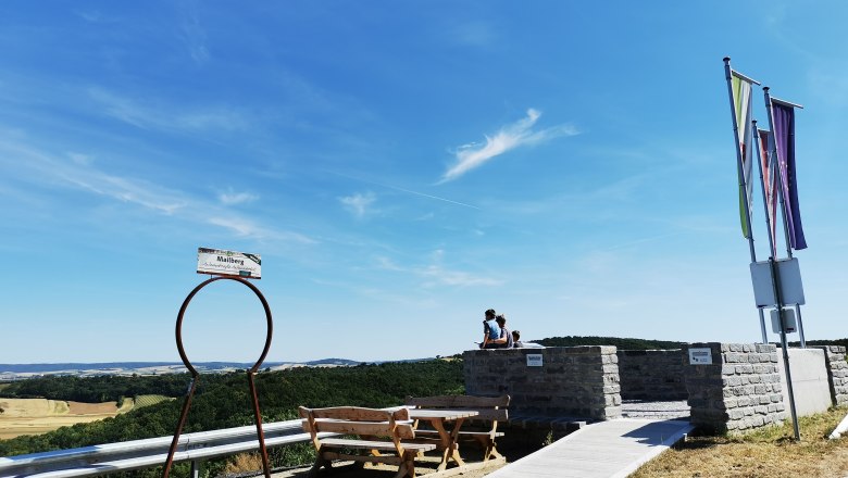 Aussichtspunkt mit Bänken und Fahnen, Blick auf Landschaft.