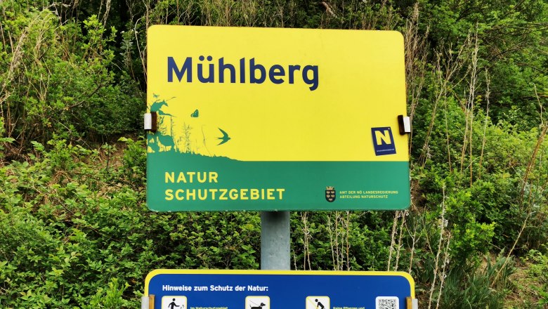 Schild des Naturschutzgebiets Mühlberg mit Hinweisen zum Schutz der Natur.