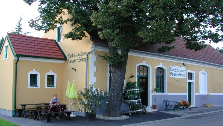 Außenansicht des Retzbacher BauernShops mit gelber Fassade und rotem Dach.