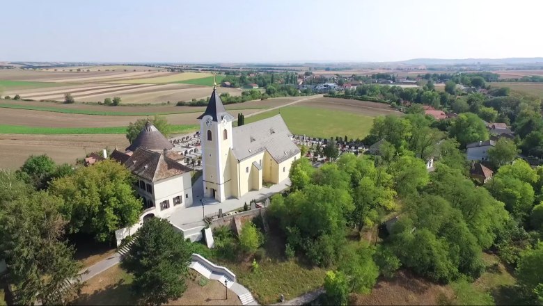 Luftaufnahme der Pfarrkirche Nappersdorf umgeben von Feldern und Bäumen.