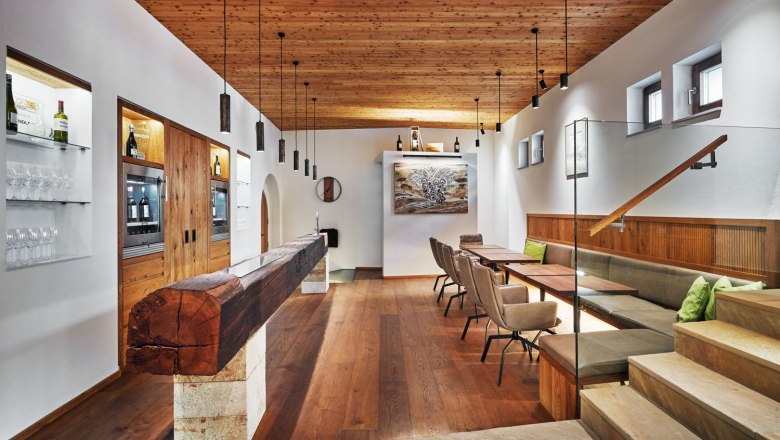 Innenansicht einer modernen Weinlounge mit Holzelementen, Tischen und Stühlen.