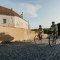 Ein Mann und eine Frau radeln bergauf entlang der Stadtmauer