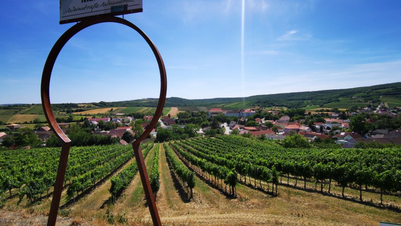 Blick auf Weinberge und Dorf durch ein großes Schlüsselloch-Symbol in Mailberg.