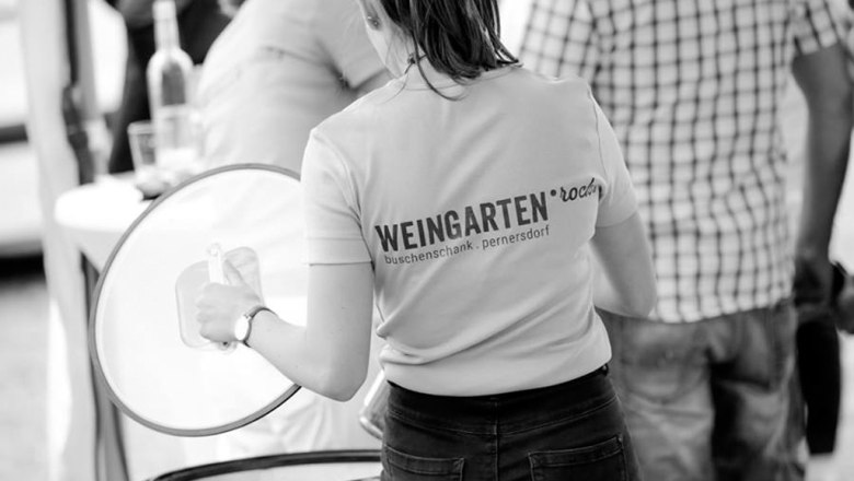 Frau in T-Shirt mit Aufschrift 'Weingarten.rocks' bei einer Veranstaltung.