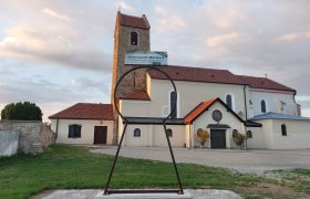 Kirche in Hohenwarth mit großem Schlüsselloch-Skulptur im Vordergrund.