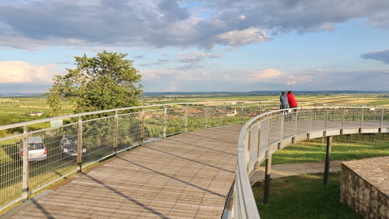 Aussichtssteg mit zwei Personen, die die Landschaft betrachten.