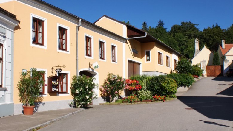 Gelbes Haus mit Blumen und blauen Himmel.